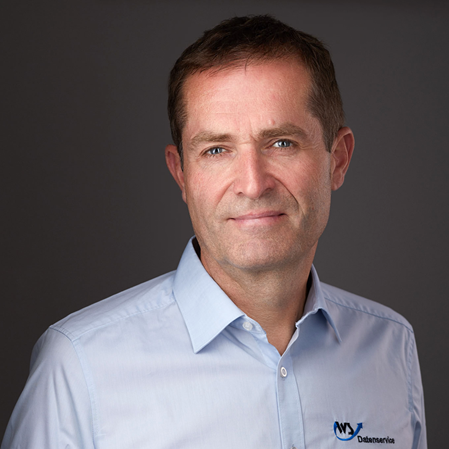 Portraits Foto von Wolfgang Greulich, Geschäftsführer WS Datenservice, Dipl. Ing. (FH) im blauen Business Hemd mit WS Datenservice Logo
